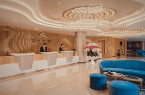 a lobby with two people standing at a counter at Golf Valley Hotel in Da Lat