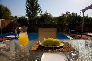 a table with a plate of grapes and a glass of orange juice at Le Torri Villas by Nidri holiday villas in Nydri