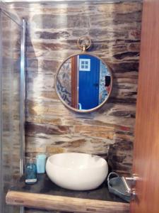 a bathroom with a sink and a mirror on a wall at Casa da Alta in Coja