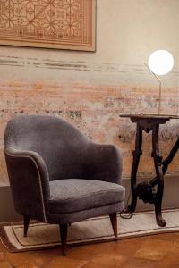 una silla sentada junto a una mesa con una lámpara en Boutique Apartment Urbino, en Urbino