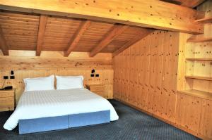 um quarto com uma cama num quarto de madeira em Residenza e Appartamenti Le Colonnine em Pozza di Fassa