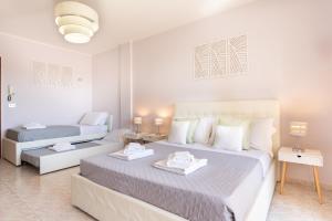 una camera bianca con 2 letti e un divano di Residenze Su Planu a Cagliari
