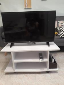 TV de pantalla plana en un soporte de TV blanco en Cute Home Bethlem, en Cuenca 11 fotos más