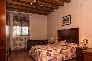 a bedroom with a bed and a chair in it at Casa Rural Casa Máxima in Yecla
