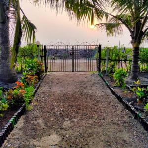 a gate at the beach with palm trees at Sagar sandhya home stay in Dapoli