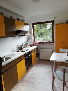 een keuken met gele en witte kasten en een tafel bij Appartment-Harzallerliebst in Bad Sachsa