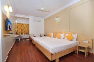 a bedroom with a large bed and a table at Hotel Vellara in Bangalore