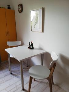 - une table blanche et une chaise dans la chambre dans l'établissement Appartment-Harzallerliebst, à Bad Sachsa