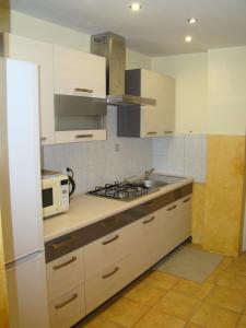 a kitchen with white cabinets and a stove top oven at Gościniec BEATA in Łagów