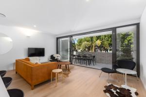a living room with a couch and a tv at 13 First Avenue Sawtell in Sawtell