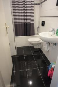 ein Bad mit einem Waschbecken und einem WC in der Unterkunft Artus Hotel in Düsseldorf