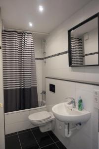 a bathroom with a sink and a toilet and a mirror at Artus Hotel in Düsseldorf