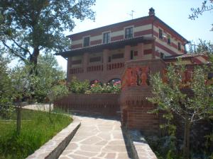 uma casa grande com uma parede de tijolos e um jardim em Le Rasse em Citerna