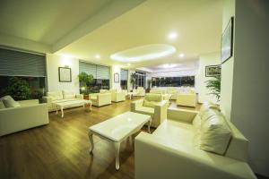 a living room with white couches and tables at Sunbay Park Hotel in Marmaris