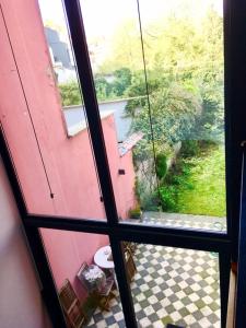 a view of a bathroom with a toilet outside a window at Rez/duplex 3 ch et jardin in Brussels