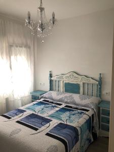 ラストレスにあるEl Trasguのベッドルーム1室(シャンデリア付きの青と白のベッド1台付)