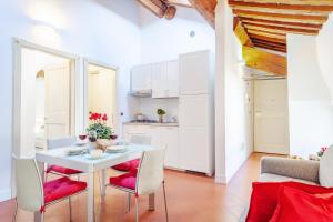 a kitchen and dining room with a white table and chairs at Ex Tribunale Palazzo Bentivoglio Apartment in Ferrara
