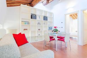 a living room with a couch and a table with red pillows at Ex Tribunale Palazzo Bentivoglio Apartment in Ferrara
