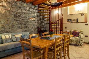a dining room with a wooden table and chairs at Castello di Zorzino Iseo lake in Riva di Solto