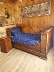 een slaapkamer met een bed met blauwe lakens en een nachtkastje bij Gîte de Montapeine in Breteau