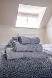 a stack of towels sitting on top of a bed at The Golden Key in Snape