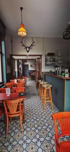 un restaurant avec des tables et des chaises en bois ainsi qu'un bar dans l'établissement Le Cerf Vert, à Dinant