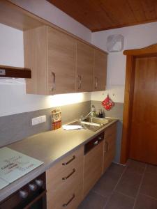 a kitchen with wooden cabinets and a sink at Appartement am Waldeck in Hauzenberg