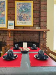 a table with red napkins and black hats on it at Angela's Beach Stays in Apollo Bay