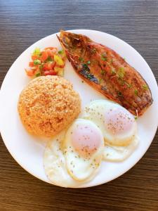 un plato de comida con huevos y salchichas y verduras en Sitio Uno Residences en Roxas City