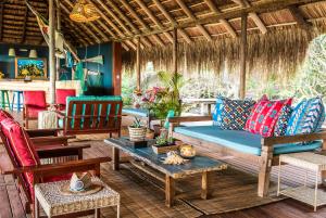 a porch with a couch and chairs and a table at Machangulo Beach Lodge in Santa Maria