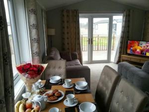 a living room with a table with fruit on it at Carnoustie Lodge in Wisbech