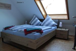 a bed with blue sheets and pillows and a window at FeWo Frankenstrasse in Rheine