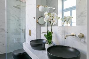 a white sink sitting under a large mirror at A77 Suites by Andronis in Athens