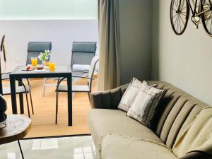 Canaryislandshost l Nazaret Suites في Nazaret: غرفة معيشة مع أريكة وطاولة مع كراسي