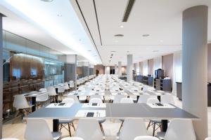 a long conference room with white tables and chairs at Catalonia Gran Hotel Verdi in Sabadell