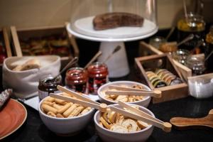a table topped with bowls of food and other foods at Catalonia Gran Hotel Verdi in Sabadell
