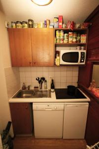 una pequeña cocina con fregadero y microondas en Le Rond Point des Pistes, en Tignes