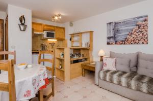 a living room with a couch and a table at Appartement Le Chamois in Megève +6 photos