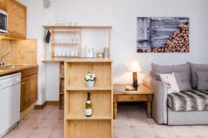 a living room with a couch and a table with a bottle of wine at Appartement Le Chamois in Megève