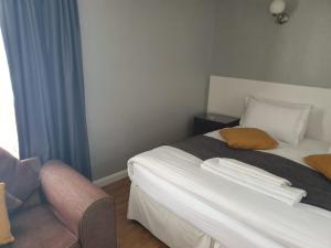 una camera d'albergo con letto e sedia di Watts Lodge a Bicester