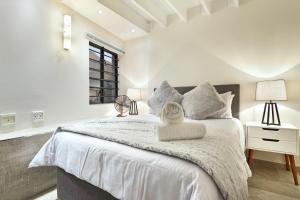 a bedroom with a large bed with white sheets at G Zero 3 @ The Breakers in Hout Bay