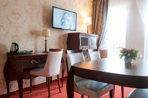 a room with a desk and a table and chairs at Hotel Splendor in Babice Nowe