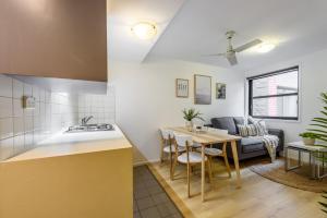 a kitchen and living room with a table and a couch at WOW Apartment on Flinders in Melbourne
