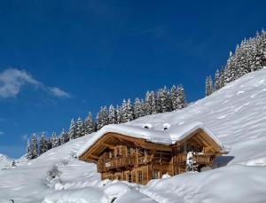 a log cabin is covered in snow at Apartchalet Jörglerhof in Gerlos