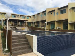 a building with a swimming pool in front of it at Imbassai Summer Flats Village in Imbassai