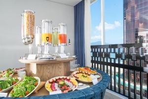 a table with plates of food on a balcony at Sofiana My Khe Hotel & Spa- Rooftop Pool Bar in Danang