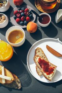 a table with a plate of food with toast and fruit at Villa de l'Etang Blanc in Seignosse