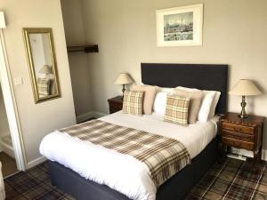a neatly made bed in a hotel room at Whitebridge Hotel in Whitebridge