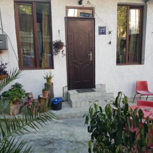 una puerta marrón al lado de una casa con plantas en Guesthouse Gia, en Tiflis