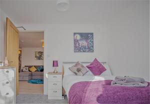 彼得伯勒的住宿－Silver Street Apartment - by TJ Serviced Property，一间卧室配有一张带紫色毯子的床
